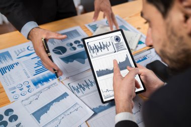Analist ekibi, tablet ekranında veri bilimi yazılım görüntüsü kullanarak dijital paneldeki finansal verileri analiz ediyor, grafiği ve grafiği analiz ediyor. İş zekası ve Fintech. Coşkulu