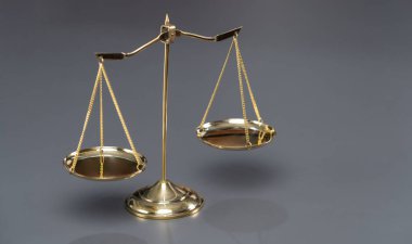 Mahkeme salonunda adalet kavramı ve ortak bir hukuki sembol olarak parlak altın dengeli bir tartı. Avukat ve avukatın adil ve eşitlik kararı için terazi uygulayın. Eşitlik