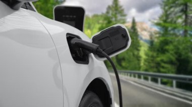 Elektrikli araç konsepti, yeşil çevre için yenilenebilir ve temiz enerjiyle çalışan EV otomobilinin varış noktasına ulaşmadan önce ormandaki şarj istasyonunun enerjisini şarj etmek için durur..
