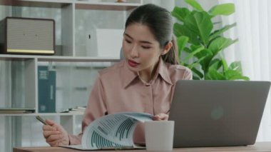 Ofiste çalışan ve dizüstü bilgisayar yazan hevesli bir iş kadını. Masasında oturmuş laptopla çalışan güzel bir ofis hanımı..