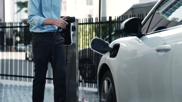 进步商人在开车绕过市中心之前 先把充电器插头从收费站安装到他的电动汽车上 可持续和清洁能源驱动的环保充电车 — 图库视频影像