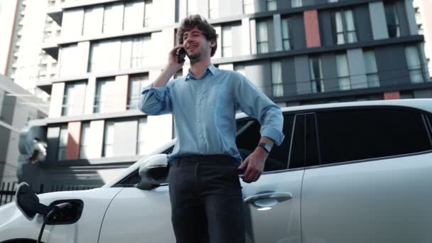 Empresário Vestido Terno Com Ambição Progressiva Apoiando Seu Veículo Elétrico — Vídeo de Stock
