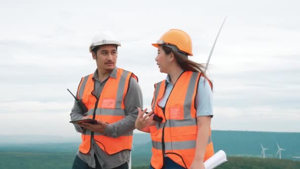 在乡村小山顶上的风电场工作的男女工程师 可再生能源和可持续能源未来生产的渐进理想 — 图库视频影像