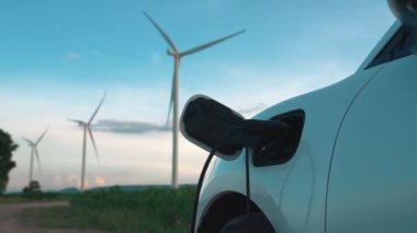 Çevreyi korumak için rüzgar türbininden yeşil ve yenilenebilir enerjiyle çalışan şarj istasyonunda şarj edilen gelişmiş gelecek enerji altyapısı konsepti.