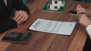 Gayretli emlak acentesi müşteriye bir emlak acentesi tarafından tavsiye edilirken, ev kredisi için müşteri sözleşmesi belgelerini sunar..