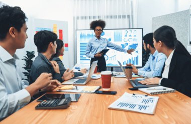 Genç Afrikalı iş kadını modern toplantıda TV ekranında veri analizi paneli sunuyor. Bir grup iş adamıyla konferans odasında iş sunumu. Uyum