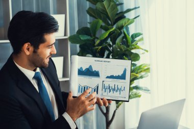 Siyah takım elbiseli profesyonel işadamı, online toplantı sırasında dizüstü bilgisayarla finansal veri ya da BI belgesi sunuyor. Etkili uzaktan çalışmanın sanal toplantı sunumuyla uzaktan çalışma konsepti. Coşkulu