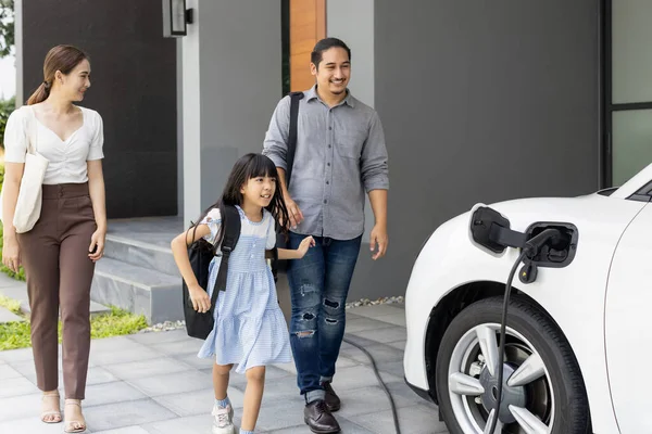 Progressive Young Parents Daughter Electric Vehicle Home Charging Station Green — Foto Stock