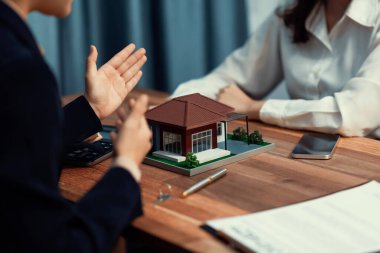 Temsilciyle ev kredisi sözleşmesini gözden geçiriyorum. Mali belgeleri ve vergi oranlarını, mülkiyet sahibi olmak için hesap makinesiyle analiz ediyorum. Yeni ev alımı ve finansman için anahtar imza. Coşkulu.