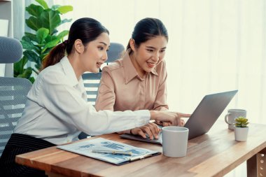 Modern ofis çalışma alanında iş birliği yapan iki genç ofis çalışanı, modern ofis çalışanı olarak profesyonelliklerini sergileyerek, dizüstü bilgisayarda tartışıyorlar ve birlikte çalışıyorlar. Coşkulu.