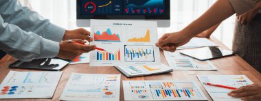 Analist ekibi, FBI Fintech 'i kullanarak mali konsolu inceliyor ve işaret ediyor. İş adamları iş görüşü için raporları inceliyor. Panorama çekimi. İnceleyin