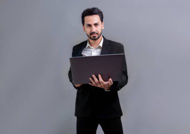 Yenilikçi teknoloji kavramına sahip başarılı bir iş adamı, ayakta duran, dizüstü bilgisayarı tutan ve telif alanı arka planında reklam ya da tanıtım için heyecanla gülümseyen. Coşkulu