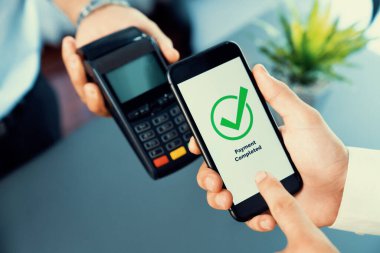 NFC QR kod cihazı ile el ele tutuşan akıllı telefon, hızlı dijital işlemler için temas kurulamayan ödeme kodlarını tarıyor. Modern yaşam tarzı ödeme teknolojisi için cep telefonundaki online bankacılık uygulaması. coşkulu
