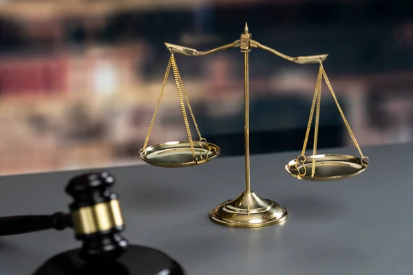 Shiny golden balanced scale and wooden gavel in law firm or lawyer office background as concept justice and a common legal symbol. Scale balance for righteous and equality judgment. Equilibrium