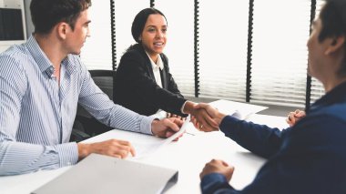 Commercial contract signed by competent people of various ethnicities and shake hands. Trade agreements, two-party business transactions.