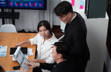 Top-view business team of financial data analysis meeting with business intelligence, report paper and dashboard on laptop for marketing strategy. Business people working together in office of harmony