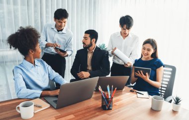 Mutlu iş adamları birlikte çalışır, şirket ofisinde tartışırlar. Profesyonel ve çeşitlilik takım çalışması iş planını bilgisayarda tartışır. Modern çok kültürlü ofis çalışanı. Uyum