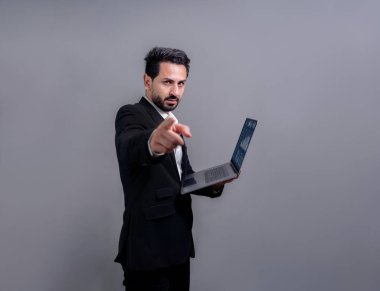 Yenilikçi teknoloji kavramına sahip başarılı bir iş adamı, kamerayı işaret eden ve dizüstü bilgisayarı tutan ve reklam ya da promosyon için arka planda heyecanla gülümseyen. Coşkulu