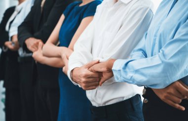 Mutlu ve gülümseyen çok ırklı ofis çalışanı, sinerjiyi ve ticari başarı için işbirliğini destekleyen bir kuyrukta el ele tutuşuyor. Modern işyerinde çeşitli profesyonel ofis çalışanları arasında bağ var. Uyum
