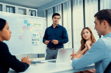 Competent office workers from various nationalities are debating, discussing and brainstorming in the meeting room. A group of employees is collaborating to achieve their business objectives.