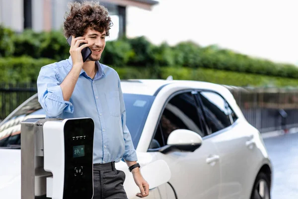Progressive Businessman Talking Phone Leaning Electric Car Recharging Public Charging — ストック写真