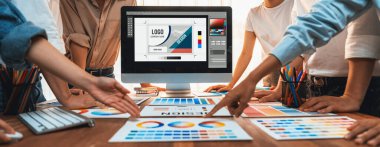 Grafik tasarımcı logo ve grafik sanatları yoğun sanat atölyesinde, dizüstü bilgisayar gösterim atölyesinde. Yaratıcı tasarım için renk paleti ve desen deneniyor. Panorama çekimi. İnceleyin