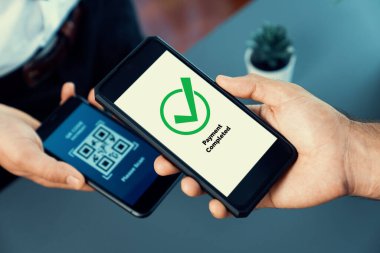 Parasız ödeme taraması için QR kodu ekranda görüntülendi. Kapalı eller, mobil uygulamadan elektronik işlem yoluyla para aktarmak için akıllı telefonu tutuyor. Hızlı ödeme için barkod teknolojisi. Coşkulu