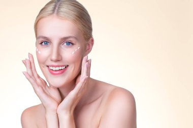 Personable beautiful perfect clean skin soft makeup woman finger applying moisturizer cream on her face under contour eye for anti aging wrinkle. Facial skin rejuvenation in isolated background.