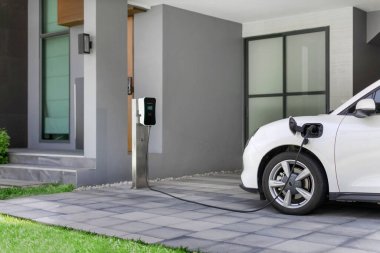 Yeşil çevre için sıfır CO2 emisyonu olan sürdürülebilir ve temiz enerjiyle çalışan EV araba ve ev şarj istasyonu konsepti. Elektrikli taşıtlar için konut alanındaki şarj noktası.