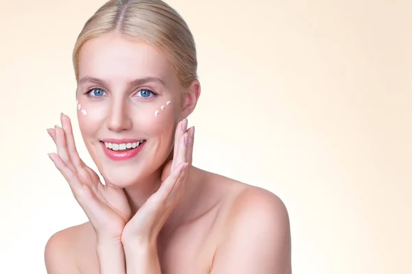 stock image Personable beautiful perfect clean skin soft makeup woman finger applying moisturizer cream on her face under contour eye for anti aging wrinkle. Facial skin rejuvenation in isolated background.