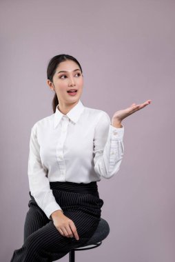 Resmi takım elbiseli, kendine güvenen Asyalı genç iş kadını, promosyon ya da reklamı hayret verici bir ifadeyle ve izole edilmiş arka planda jestle göstermek için el ele tutuşuyor. Coşkulu.