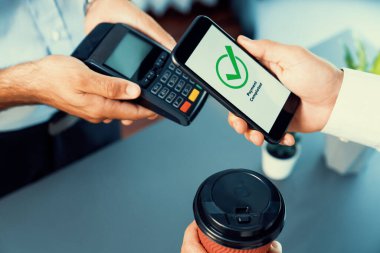 NFC QR kod cihazı ile el ele tutuşan akıllı telefon, hızlı dijital işlemler için temas kurulamayan ödeme kodlarını tarıyor. Modern yaşam tarzı ödeme teknolojisi için cep telefonundaki online bankacılık uygulaması. coşkulu