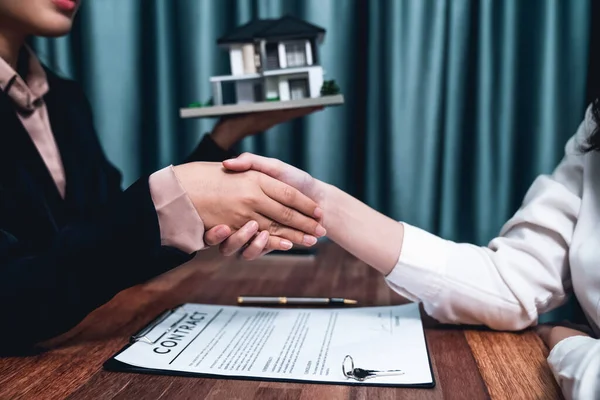 Successful house loan agreement sealed with a handshake. Buyers and agents celebrate the home ownership of property with a sense of accomplishment and satisfaction. Enthusiastic
