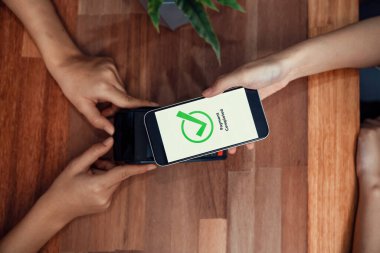 QR kodu parasız ödeme taraması için ekranda gösterilir. Kapalı eller, mobil uygulamadan elektronik işlem yoluyla para aktarmak için akıllı telefonu tutuyor. Hızlı ödeme için barkod teknolojisi. Coşkulu.