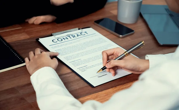stock image Closeup hand signing contract document with pen, sealing business deal with signature. Businesspeople finalizing business agreement by writing down signature on contract paper. Enthusiastic