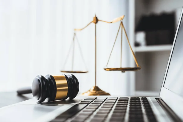 stock image Symbolizing justice and legal authority, golden balanced scale and gavel on desk with laptop in law office background, reflecting concept of equality and fair judgment by lawyer and judge. equility