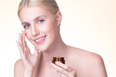 Closeup personable beautiful perfect clean skin soft makeup woman finger applying moisturizer cream on her face for anti aging wrinkle. Facial rejuvenation with expressive hand gesture putting cream.