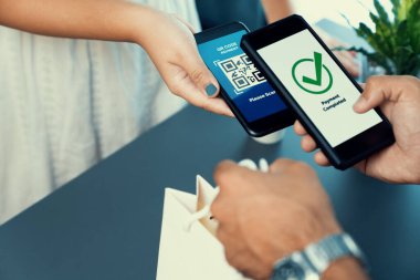 Parasız ödeme taraması için QR kodu ekranda görüntülendi. Kapalı eller, mobil uygulamadan elektronik işlem yoluyla para aktarmak için akıllı telefonu tutuyor. Hızlı ödeme için barkod teknolojisi. Coşkulu