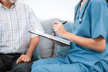 A young female doctor inquires about personal information of a contented senior at home. Medical care for the elderly, elderly illness, and nursing homes, home care.