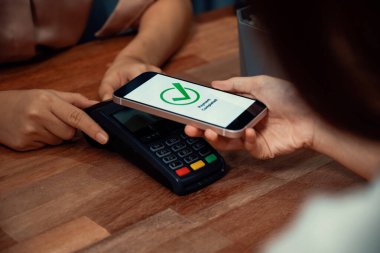 QR kodu parasız ödeme taraması için ekranda gösterilir. Kapalı eller, mobil uygulamadan elektronik işlem yoluyla para aktarmak için akıllı telefonu tutuyor. Hızlı ödeme için barkod teknolojisi. Coşkulu.