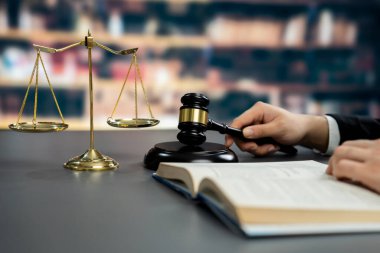 Avukatı ya da avukatı dava ya da dava açmaya hazırlanıyor, hukuk fakültesi konsepti için kütüphanedeki masasında hukuk kitabı okuyor ya da okuyor, hukuki sembollerle süslenmiş. Eşitlik