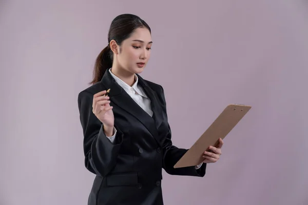 自信的年轻女商人站在孤立的背景上 拿着剪贴板 穿着正式的黑色西服 办公室女职员或经理 外表聪明 很有激情 — 图库照片