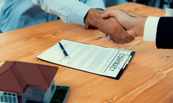 Successful house loan agreement sealed with a handshake. Buyers and agents celebrate the home ownership of property with a sense of accomplishment and satisfaction. Fervent