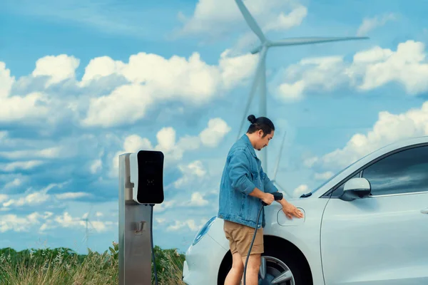 Elektrikli Arabasıyla Ilerici Bir Adam Arabası Gelecekteki Sürdürülebilir Enerji Kavramı — Stok fotoğraf