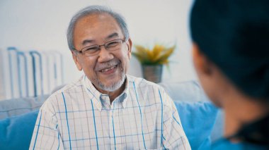 A young female doctor inquires about personal information of a contented senior at home. Medical care for the elderly, elderly illness, and nursing homes, home care.