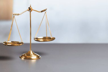 Mahkeme kütüphanesinin arka planında adalet ve adalet sembolü olarak parlak altın dengeli bir terazi. Avukat ve avukatın adil ve eşitlik kararı için terazi uygulayın. denge
