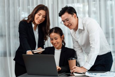 Harmony in office concept as business people analyzing dashboard paper together in workplace. Young colleagues give ideas at manager desk for discussion or strategy planning about project.