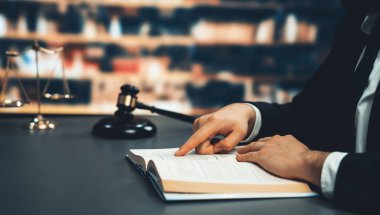 Avukatı ya da avukatı dava ya da dava açmaya hazırlanıyor, hukuk fakültesi konsepti için kütüphanedeki masasında hukuk kitabı okuyor ya da okuyor, hukuki sembollerle süslenmiş. Eşitlik