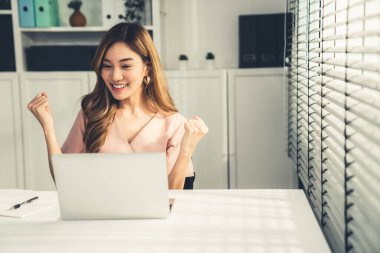A young female employee receives a promotion, good news or finished her task and overjoyed for being a competent worker.