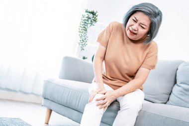 An agonizing elderly woman is experiencing chest pain. Medical attention, medical service for seniors.